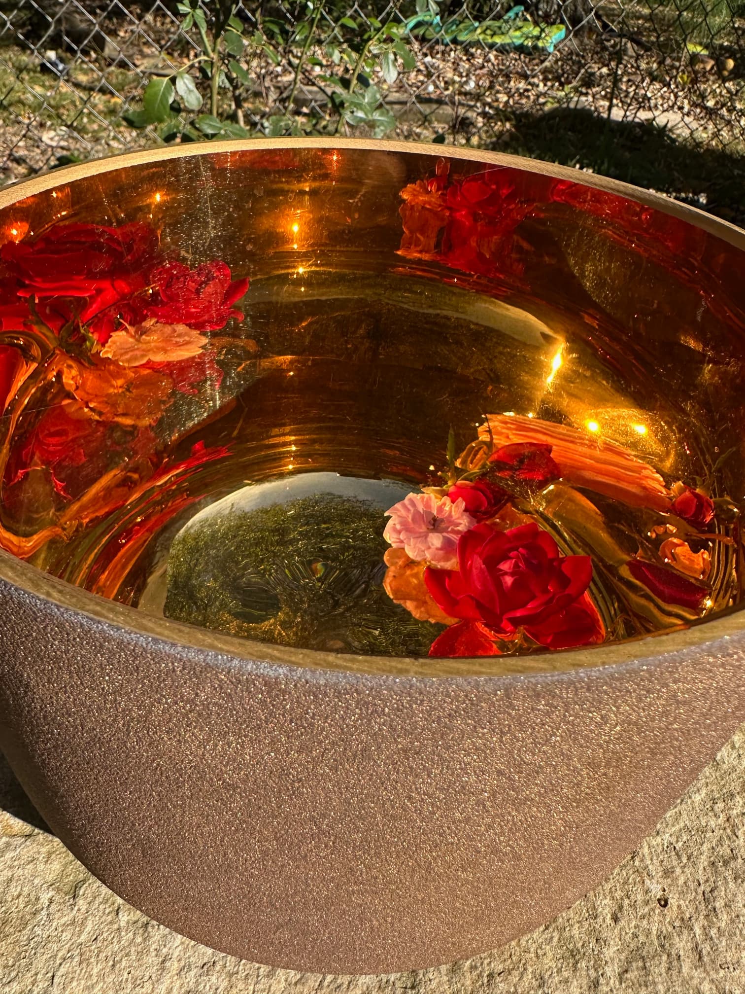Golden bowl of water with three floating flowers used in the Galaxies of Love Spray creation, symbolizing vibrational medicine, holistic healing, and heart-opening energy