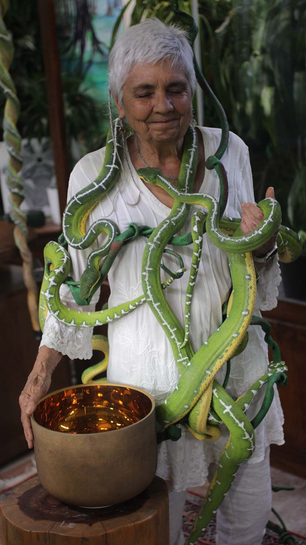 Star, the founder of Star Essence, holding emerald boas with a singing bowl during the serpent essence ceremony, symbolizing healing, ceremony, and spiritual wellness.