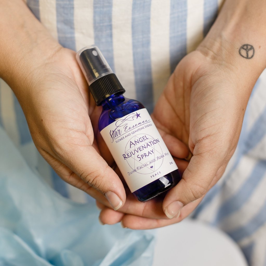 Hands holding Angel Rejuvenation Spray, a spiritual wellness and holistic medicine aura mist by Star Essence